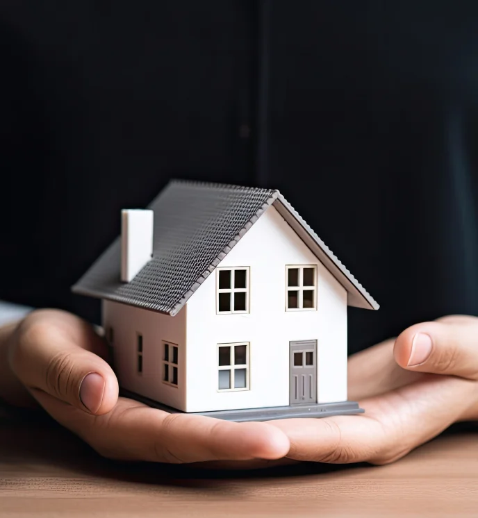 Hands holding a small house model